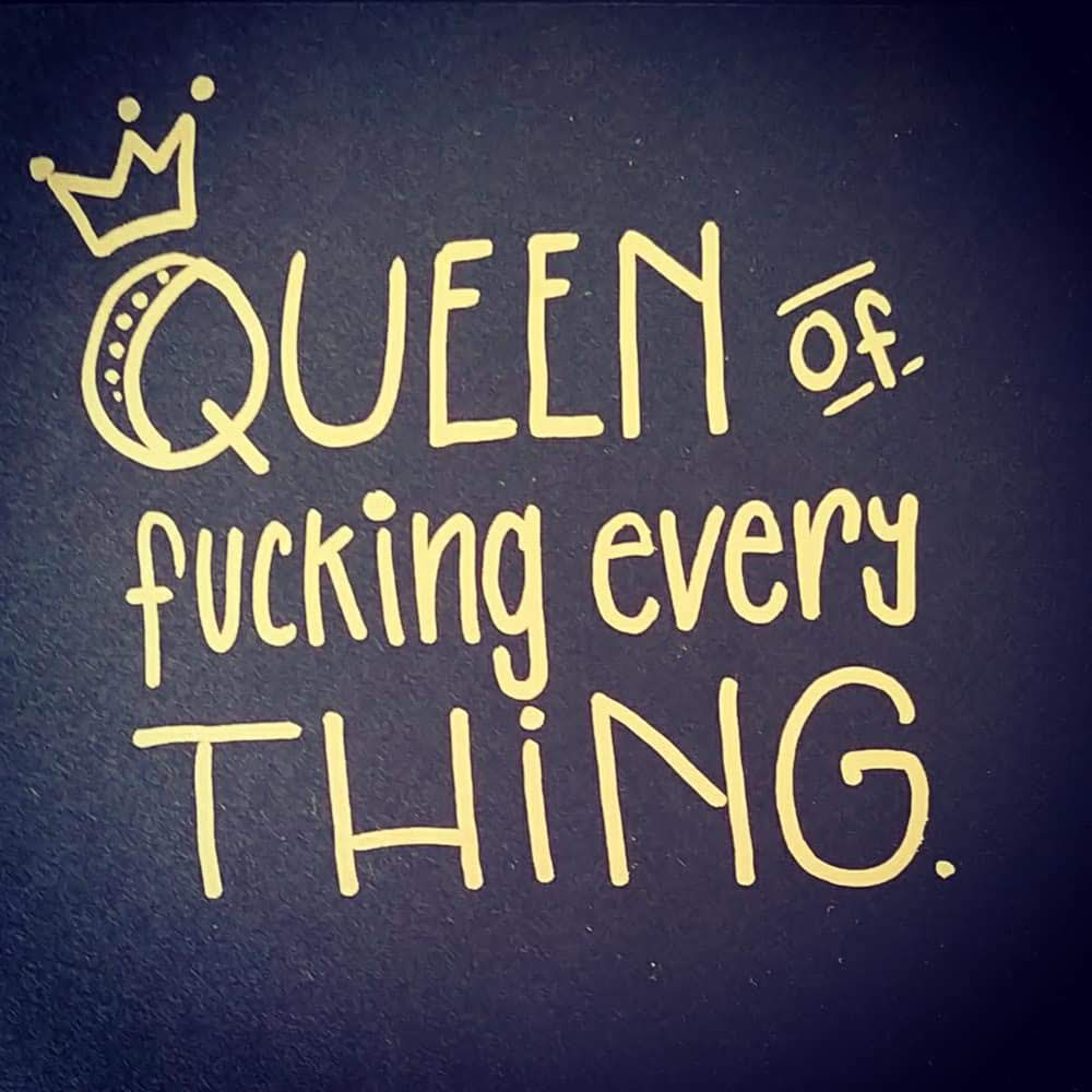 Motivations Spruch als edles Handlettering mit Gold Marker auf schwarzem Papier "Queen of fucking everything". Zusätzlich rundet ein Icon als Krone das Lettering ab.